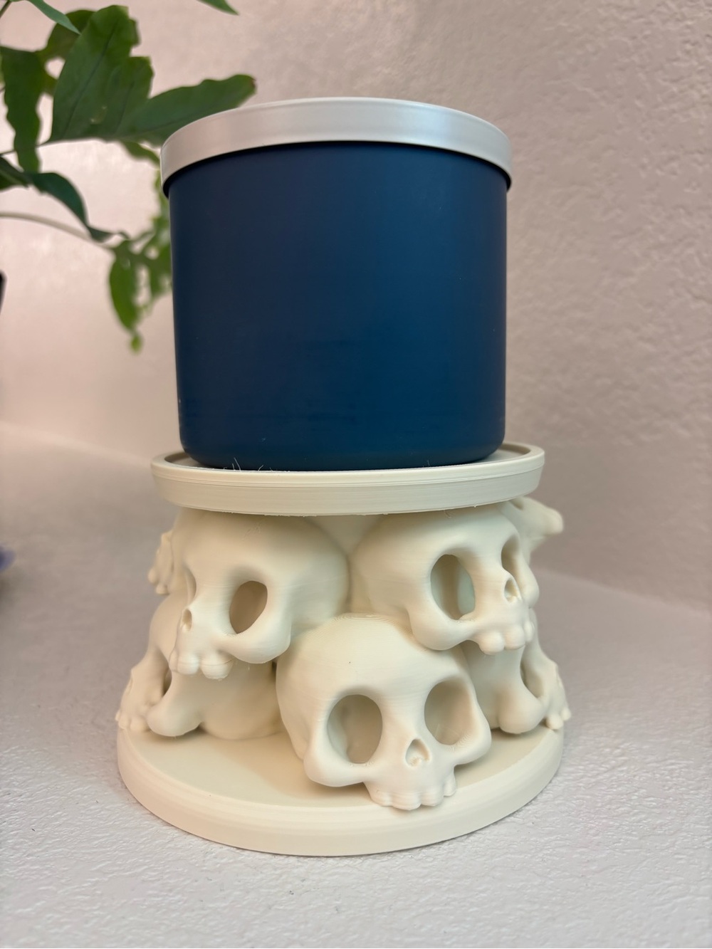 3D printed plastic pedestal candle holder featuring stacked skulls